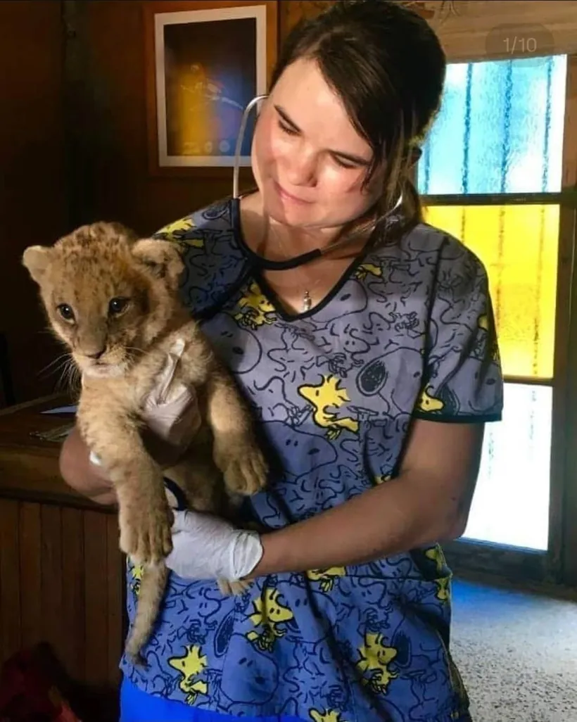 La Directora Médica del Bioparque Huellitas sosteniendo a un cachorro de león durante una de sus capacitaciones en manejo de fauna